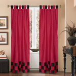 Red sari tab top curtains hung at a window