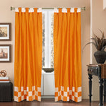 Orange sari tab top curtains hung at a window