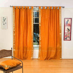 Mustard sari tab top curtains hung at a window