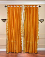 Mustard sari grommet top curtains hung at a window