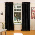 Black velvet grommet top curtains hung at a window