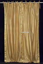 Golden sari tie top curtains hung at a window