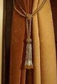Golden sari curtain tiebacks holding a panel open