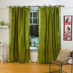 Olive green sari tie top curtains hung at a window
