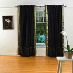 Black sari rod pocket curtains hung at a window