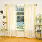Cream sari rod pocket curtains hung at a window