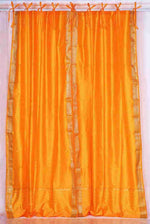 Pumpkin sari tie top curtains hung at a window