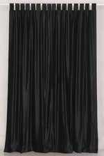 Black velvet tab top curtains hung at a window