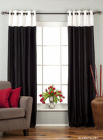 Black velvet ring top curtains hung at a window