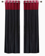 Burgundy velvet ring top curtains hung at a window