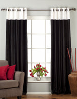 Black velvet ring top curtains hung at a window