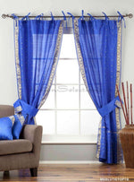 Blue sari tie top curtains hung at a window