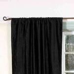 Black velvet rod pocket curtains hung at a window