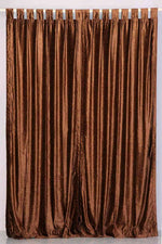 Brown velvet tab top curtains hung at a window