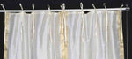 Cream sari tie top curtains hung at a window