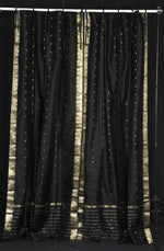 Black sari tie top curtains hung at a window