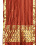 Rust sari rod pocket curtains hung at a window