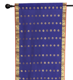 Blue sari rod pocket curtains hung at a window