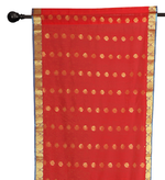 Red sari rod pocket curtains hung at a window