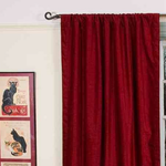 Burgundy velvet rod pocket curtains hung at a window
