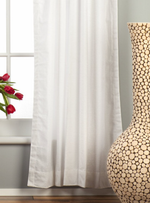 White velvet rod pocket curtains hung at a window