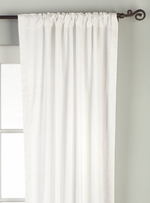 White velvet rod pocket curtains hung at a window
