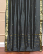 Grey sari grommet top curtains hung at a window