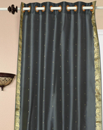 Grey sari grommet top curtains hung at a window
