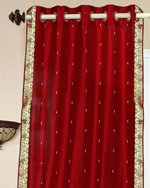 Red sari grommet top curtains hung at a window