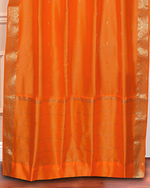 Pumpkin sari grommet top curtains hung at a window