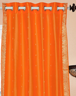 Pumpkin sari grommet top curtains hung at a window