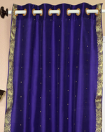 Purple sari grommet top curtains hung at a window