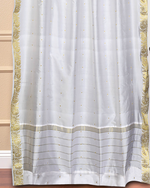 White sari grommet top curtains hung at a window