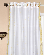 White sari grommet top curtains hung at a window