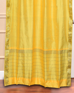Yellow sari grommet top curtains hung at a window
