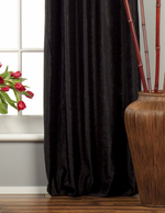 Black velvet ring top curtains hung at a window