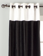 Black velvet ring top curtains hung at a window