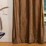 Taupe velvet grommet top curtains hung at a window