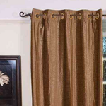 Taupe velvet grommet top curtains hung at a window