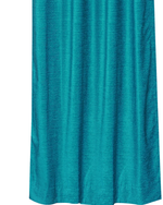 Turquoise velvet ring top curtains hung at a window