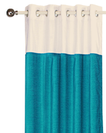 Turquoise velvet ring top curtains hung at a window
