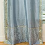 Gray sari tie top curtains hung at a window