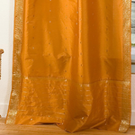 Mustard sari tie top curtains hung at a window