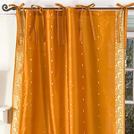 Mustard sari tie top curtains hung at a window