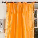 Pumpkin sari tie top curtains hung at a window