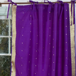 Purple sari tie top curtains hung at a window