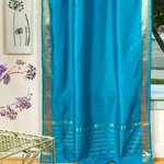 Turquoise sari tie top curtains hung at a window
