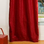 Burgundy velvet tab top curtains hung at a window