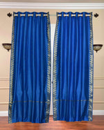 Blue sari grommet top curtains hung at a window