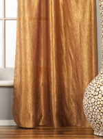 Gold sari grommet top curtains hung at a window